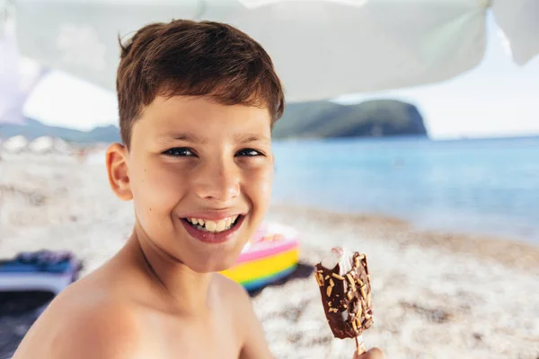 男孩站在海滨边吃冰淇淋 小男孩正在度假 请人吃冰淇淋 — 图库照片