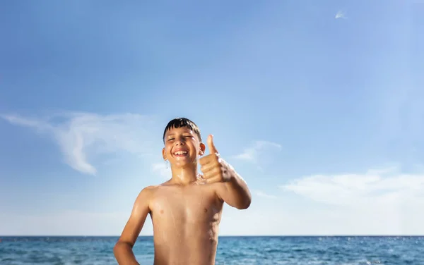 一个9岁的男孩被描绘在海滩上 全身湿透了 他的棕色头发湿透了 水滴滴落下来时粘在脸上 — 图库照片
