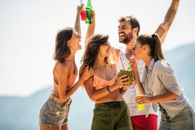 Genç arkadaşlar güneşli bir günde kumsalda eğleniyorlar..