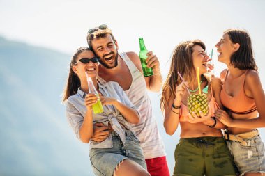 Genç arkadaşlar güneşli bir günde kumsalda eğleniyorlar..