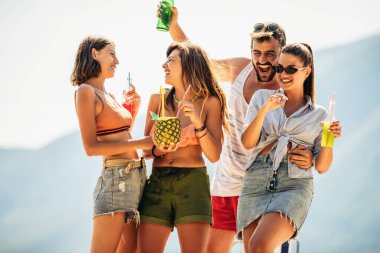 Genç arkadaşlar güneşli bir günde kumsalda eğleniyorlar..