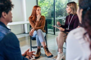 The group listens as the therapist makes a point of solving problems. clipart