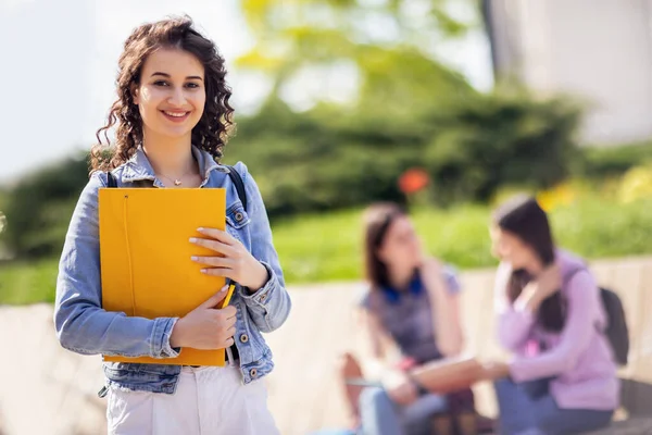 Studentin Steht Mit Ihrem Notizbuch Während Ihre Freunde Hinter Ihr — Stockfoto