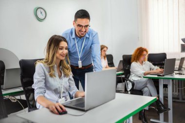 Genç öğretmen genç öğrencilere sınıfta bir programlama dersi veriyor..