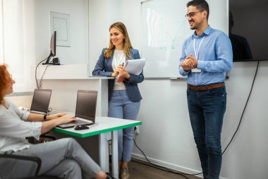 Genç öğretmenler genç öğrencilere sınıfta bir programlama dersi veriyor..