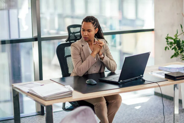 アフリカ系アメリカ人女性の会社の財務責任者は デスクに座ってラップトップを使用して — ストック写真