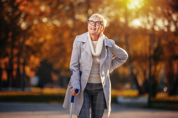 Starsza Kobieta Chodząca Laską Podczas Bólu Kolorowym Parku Jesienią — Zdjęcie stockowe