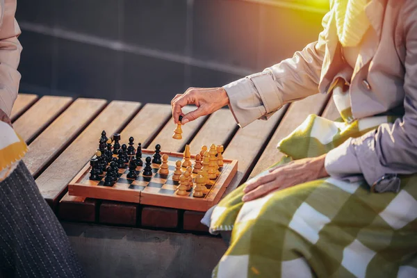 2人の年上の女性がチェスをしていて 秋のカラフルな公園でそれを楽しんでいます — ストック写真