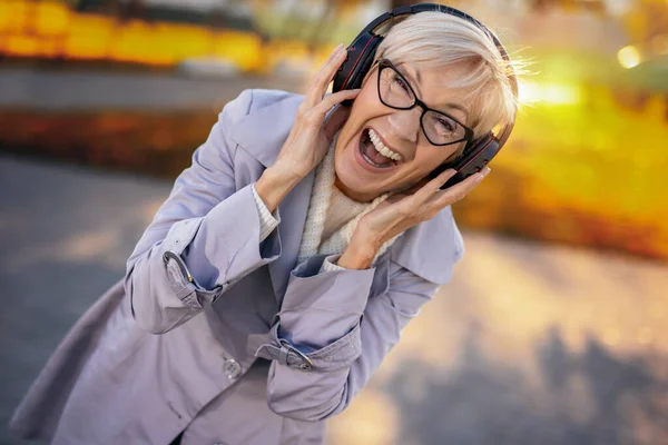 Äldre Kvinna Som Lyssnar Musik Sina Trådlösa Hörlurar Den Färgglada — Stockfoto