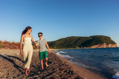 Erkek ve kız kardeş sahilde eğleniyorlar.