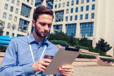 İşadamı tablet kullanıyor ve işi dışında kahve içiyor..