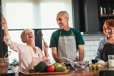 Akşam yemeği partisinde bir grup kıdemli arkadaş yemek pişiriyor..