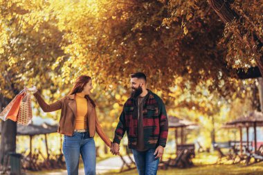 Sonbahar Park alışveriş torbaları ile mutlu çift