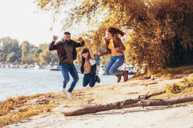 Ebeveynler ve oğulları nehir kenarında yürüyor kırsalda tatil yapıyorlar.