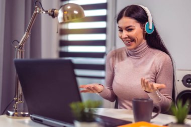 A young woman is having an online video meeting or job interview on a laptop at home.
