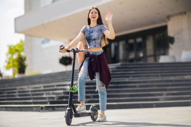 Mobiletli öğrenci dışarıda temiz havada kahve tutuyor.