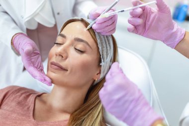 Kozmetik uzmanı, kaş kaldırma ve botoks yapmadan önce dişinin yüzüne hatlar çiziyor. Estetik güzellik yaşlanmayı önleme, yüz gerdirme ameliyatı