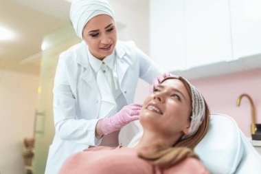 Doktor iğneyle estetik işlemler yapıyor.