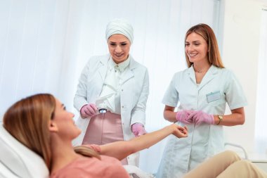 Dermatolog mol veya akne olan bir dermatoscope hastanın inceliyor. Melanom önleme