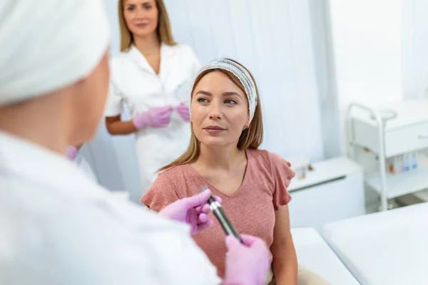 stock image A doctor is explaining to a patient what aesthetic procedure will she be doing