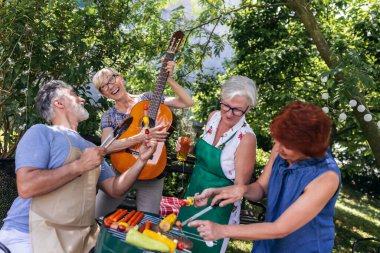 Yaşlı insanlar barbekü yapıyor, içki içiyor, hatıralar yaratıyor ve gülüyorlar..