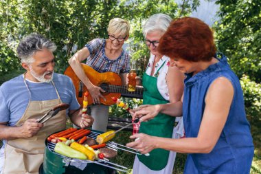 Yaşlı insanlar barbekü yapıyor, içki içiyor, hatıralar yaratıyor ve gülüyorlar..