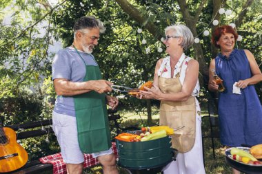 Yaşlı insanlar barbekü yapıyor, içki içiyor, hatıralar yaratıyor ve gülüyorlar..