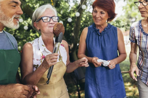 Yaşlı insanlar barbekü yapıyor, içki içiyor, hatıralar yaratıyor ve gülüyorlar..
