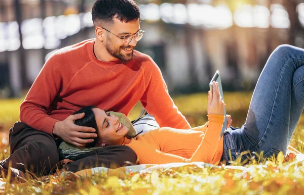 年轻夫妇一边喝咖啡 一边看着石碑 五彩缤纷的公园里阳光灿烂的秋日 — 图库照片