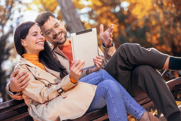 Young Couple Looking Tablet Sitting Bench Sunny Autumn Day Colorful — Stock Photo, Image