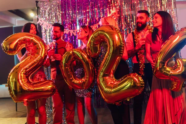 一群年轻人在夜总会庆祝新年 他们手里拿着金球数 — 图库照片