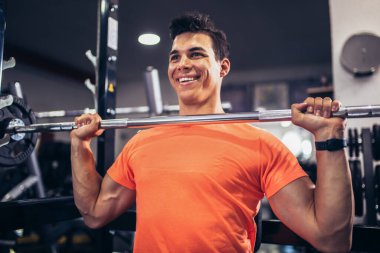 Spor salonunda egzersiz yapan yakışıklı bir genç.