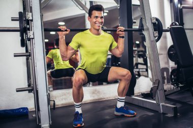 Spor salonunda egzersiz yapan yakışıklı bir genç.