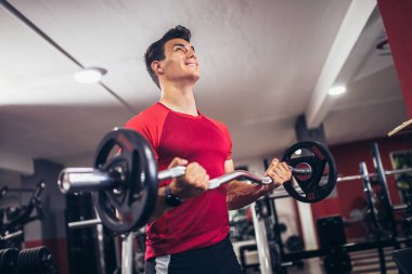 Spor salonunda egzersiz yapan yakışıklı bir genç.