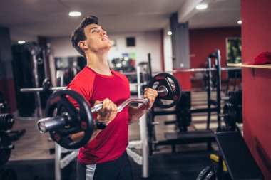 Spor salonunda egzersiz yapan yakışıklı bir genç.