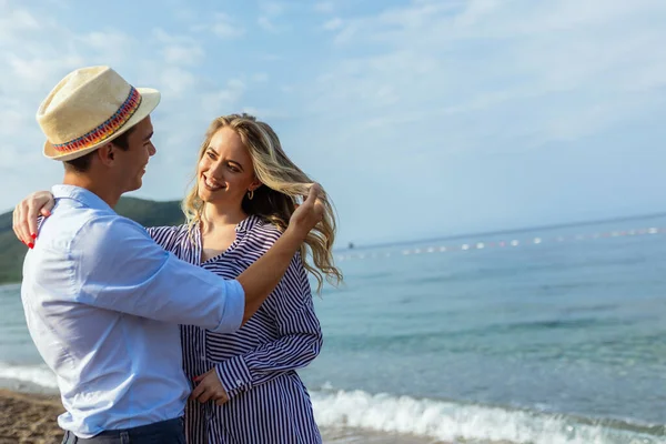幸せな若いカップル笑いとビーチで抱擁 — ストック写真