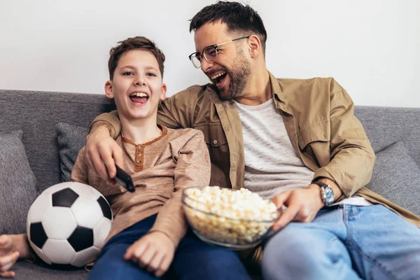 ポップコーンを食べながらサッカーを見ている父と息子 — ストック写真