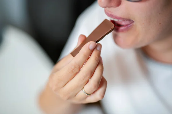 Close-up of woman eating chocolate bar