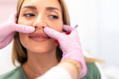 Doktor estetik ameliyatlardan önce iğneyi hazırlar.