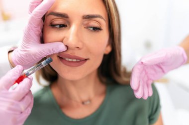 Doktor estetik ameliyatlardan önce iğneyi hazırlar.