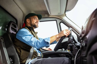 Çekici servisinde çalışan ve kamyonunu süren yakışıklı bir genç..