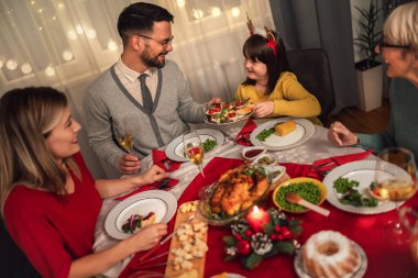 Mutlu çok nesilli aile evde birlikte yemek yiyor. Evde Noel yemeğinde aile.