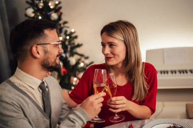 Bir akşam yemeği sırasında yemek masasında oturup gülen bir çift. 