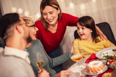 Mutlu çok nesilli aile evde birlikte yemek yiyor. Evde Noel yemeğinde aile.