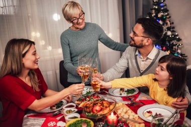 Mutlu çok nesilli aile evde birlikte yemek yiyor. Evde Noel yemeğinde aile.