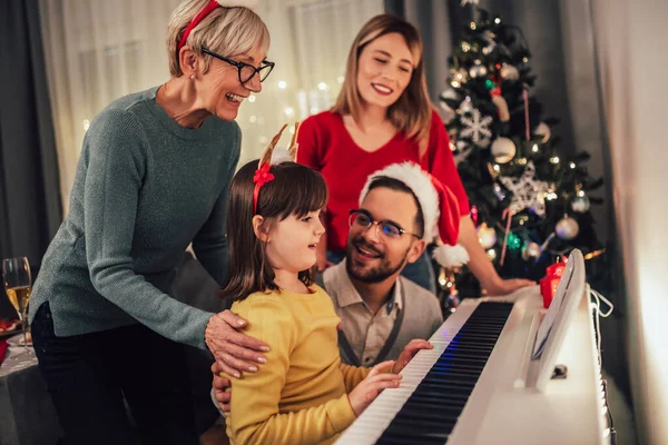 Familia Mientras Disfruta Música Que Hija Toca Piano Durante Navidad —  Fotos de Stock