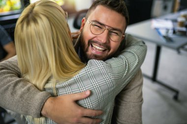 Kadın ve erkek grup terapisi seansında kucaklaşıyorlar, sorunları birlikte aşıyorlar.