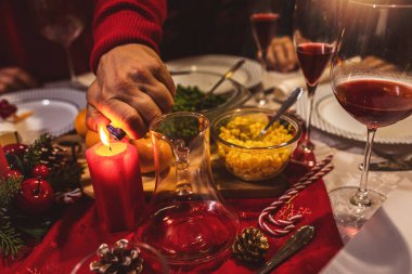 Yemek masasında mum yakmak. Aile Noel yemeği yiyor..