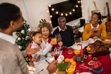 Aile Noel arifesinde masada eğleniyor..