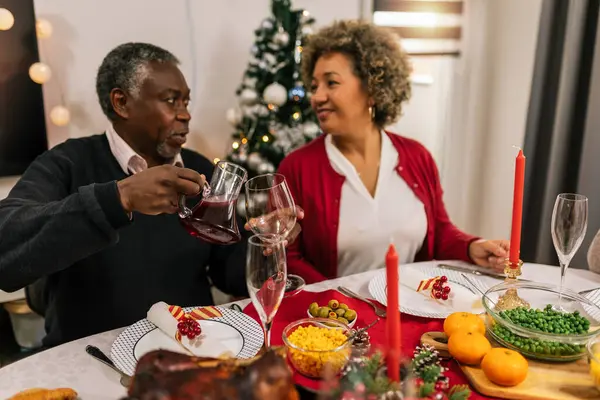 Grandparents drinking wine on the family Christmas dinner.